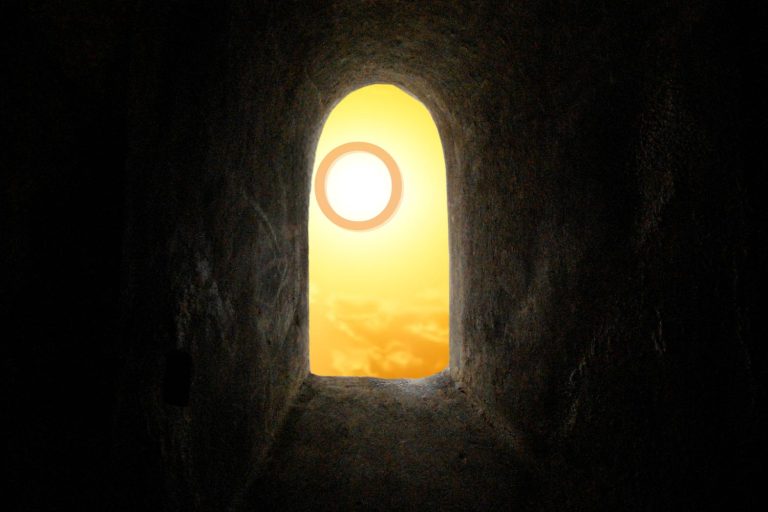 an orange "O" glowing in the sunshine, viewed through the opening of a cave
