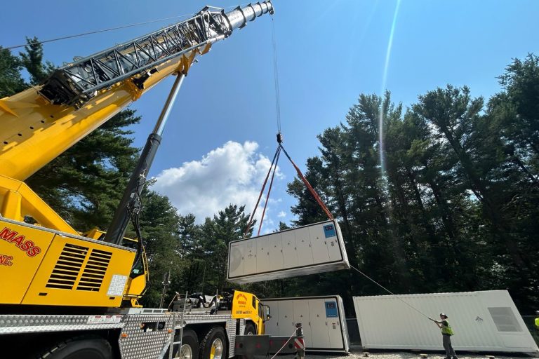 battery storage unit being lowered by crane